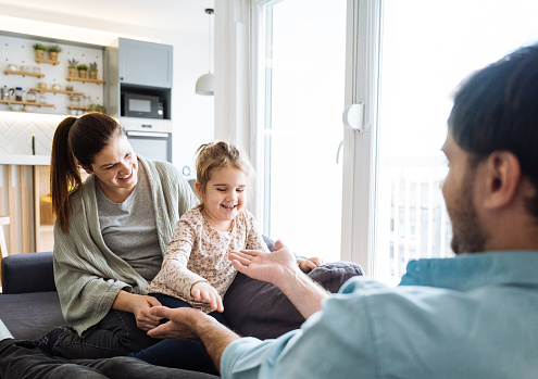 Parents playing with daughter at home