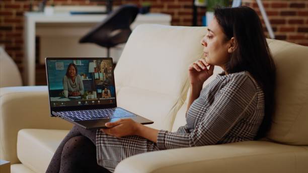 istock Internet videocall host on couch at home engaging in discussions with trainees 2009827942