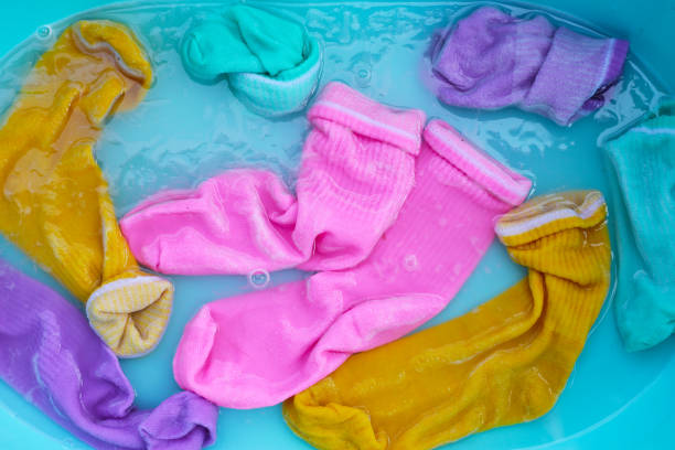 istock Dirty socks soaked in water, dissolving detergent in basin. 2009839475
