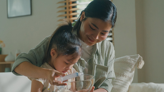 Closeup of Mom takes Care of her daughter who gets sick and has a high fever, cold, and flu, and does nasal irrigation at home. Illness Girl with a medical condition and family wellness concept.
