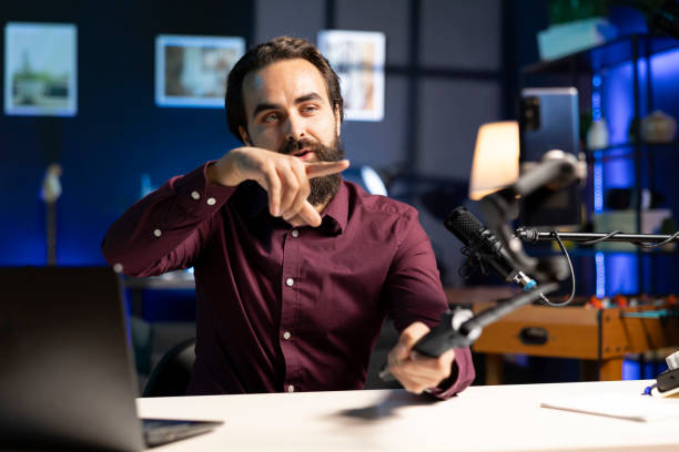 istock Influencer pointing to camera, making energetic hand movements while filming vlog with mobile phone 2009885797
