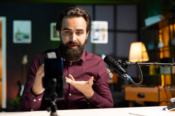 istock Tech guru presenting V mount battery, filming review using professional microphone. 2009897451