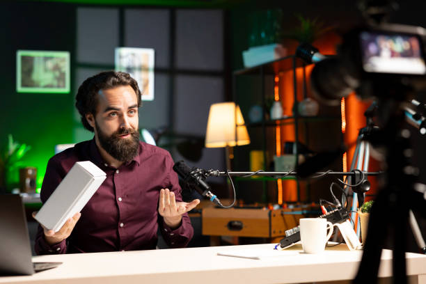 istock Man showing phone box to viewers, recording with high tech devices 2009907145