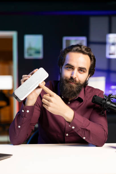 istock Influencer pointing to music playing gear to his subscribers, recommending it 2009908791