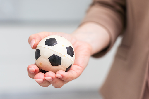 Woman hand with football on white background. High quality photo