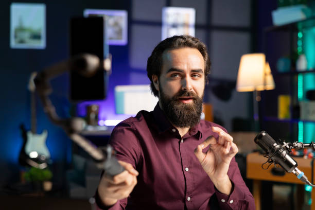 istock ASMR creator with high tech mic and smartphone on selfie stick does relaxing ambient sounds 2009911151