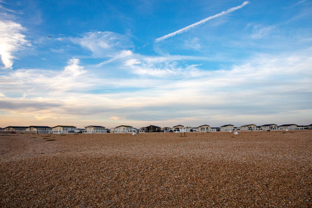 Mobile holiday homes park in Selsey at shingle beach in sunset, golden hour light