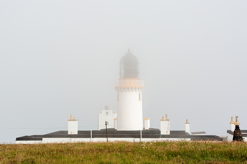 Dunnet Head Lighthouse covered of low clouds