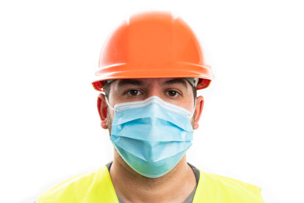 istock Close-up of constructor man in work attire wearing surgical mask 2009959217