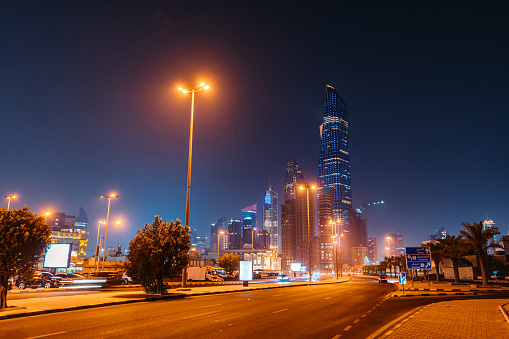 Luminous skyscrapers and modern architecture of Kuwait City against the dark night sky.