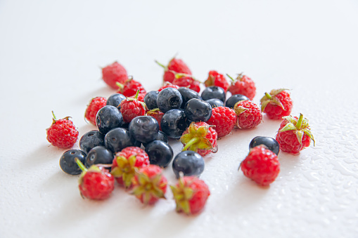 Berry mix in a white bowl, white background, strawberries, blueberries, raspberries, redcurrants mixed together, healthy snack, berries in a bowl, focus in details, sweet dessert, vitamin, good mix