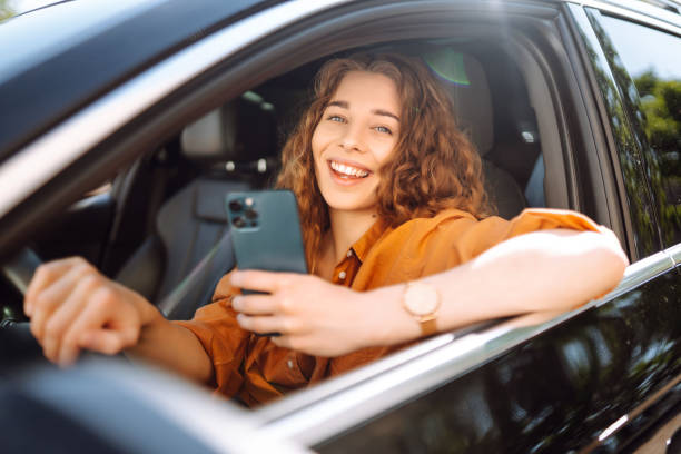 istock Woman driver in a car with a phone in her hands. 2010009274