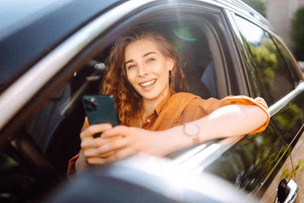 istock Woman driver in a car with a phone in her hands. 2010009278