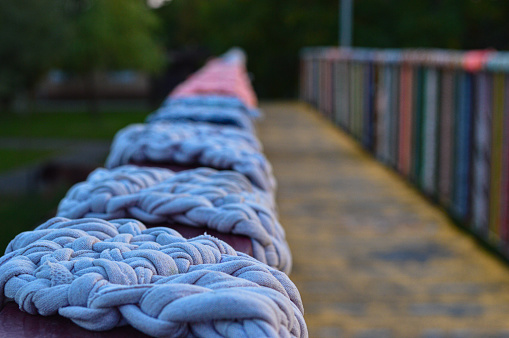 A closeup of yarn wrapped on a bridge railing