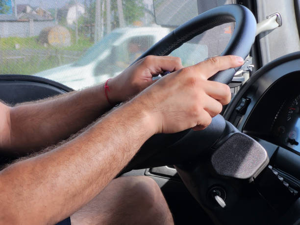 istock The driver's hands on the black steering wheel while driving 2010039438