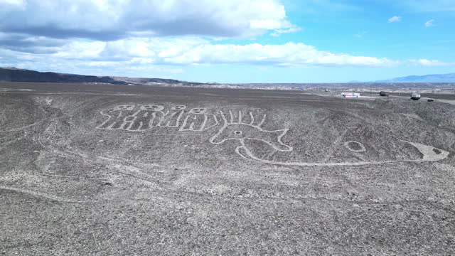 Scenic aerial view of desert mountainscape with the Nazca lines humanoid creatures in Peru.