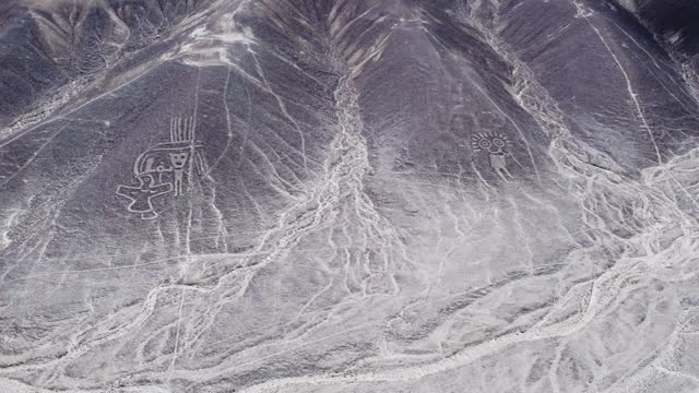 Humanoid creatures in Nazca, top down aerial view of valley in Peru.
