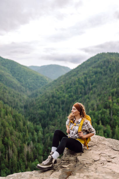 istock Young woman with backpack on mountain peak enjoying nature. 2010044333