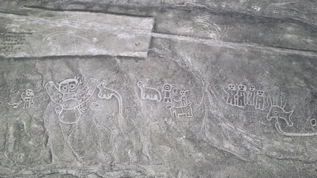 Top down aerial above humanoid creatures geoglyphs in the Nazca desert, Peru.