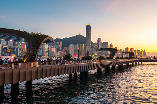 Hong Kong - August 8, 2023: As the sun sets over the bustling metropolis of Hong Kong, the iconic Victoria harbor bridge stands tall, connecting the city's impressive skyline to the tranquil waters below