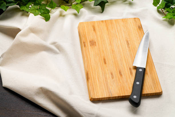 Kitchen knife and cutting board on wooden table