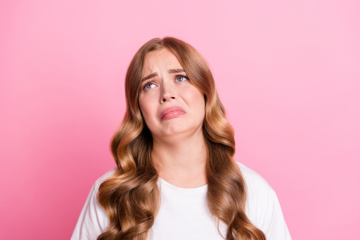 Photo of young girl unhappy sad moody looking empty space offended crying when conflict with boyfriend isolated on pink color background.