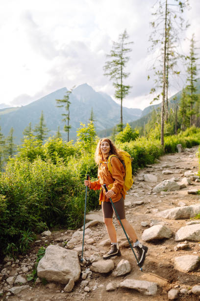 istock Happy backpacker woman hiking, camping through mountain forest. 2010062002