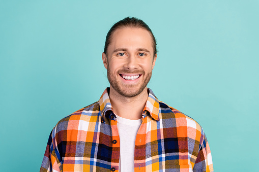 Portrait of good mood cheerful man with stubble wear flannel plaid jacket smiling at camera isolated on turquoise color background.