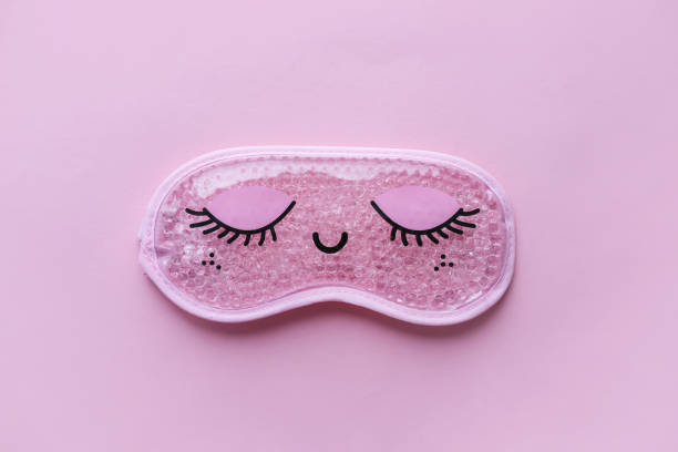 istock Pink sleep mask with closed eyes on it on pink background. Top view, flat layer. The concept of vivid healthy dreams. 2010098215