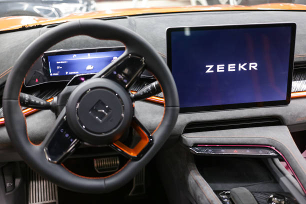 Zeekr 001 EV car interior - dashboard, player, steering wheel with logo and buttons, speedometer and tachometer. Zeekr logo on steering wheel. Zeekr is a Chinese electric car brand by Geely.