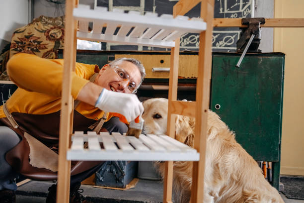 istock Mature man working in home garage painting shelf that he made 2010135051