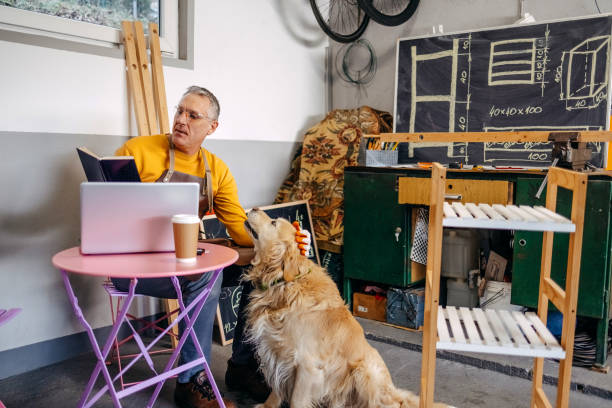 istock Man and his dog spending time together working in garage 2010135081