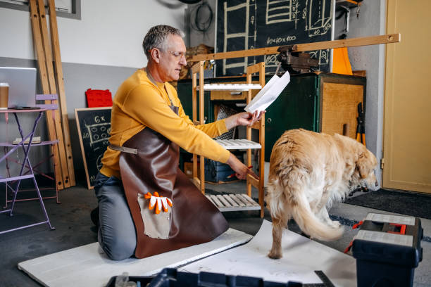 istock Man and his dog spending time together working in garage 2010136651