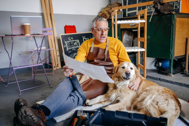 istock Man and his dog spending time together working in garage 2010137187