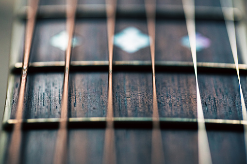 Electrical guitar headstock, machine heads and metal strings closeup. Electric guitar black and white color, detail. Music instruments. Concept international music day. Macrophotography. Soft focus