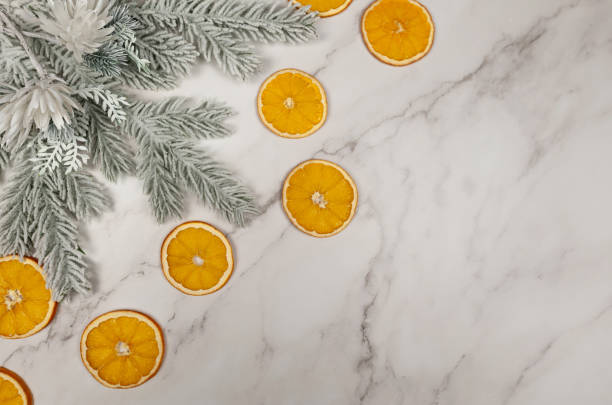 Christmas composition, dried orange slices, fir tree branches on white marble background. Christmas, New Year, winter concept.