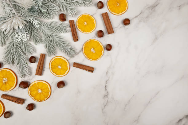 istock Christmas composition, dried orange slices, fir tree branches, cinnamon sticks, hazelnuts on white marble background. 2010151216