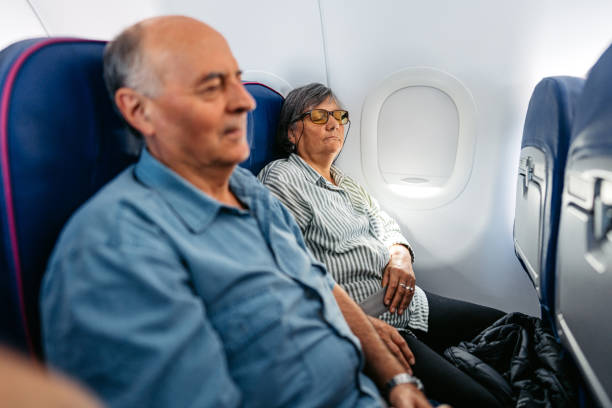 istock Senior Couple Sleeping In An Airplane 2010186547