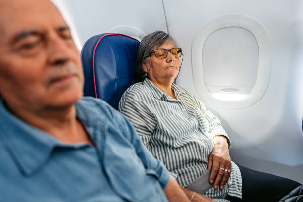 istock Senior Couple Sleeping In An Airplane 2010187662