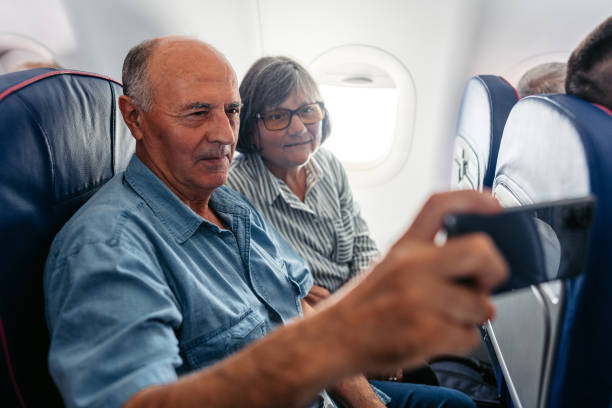 istock Senior Couple Taking Selfies In An Airplane 2010188214