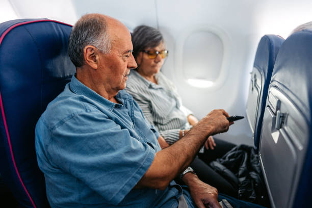 istock Senior Couple Using Smart Phone In An Airplane 2010190961