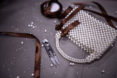 Close up of elegant white pearl beaded purse with brown bow