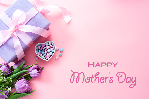 Mother's Day design concept background with tulips, candies and gift box on pink background. High resolution 42Mp studio digital capture taken with Sony A7rII and Sony FE 90mm f2.8 macro G OSS lens