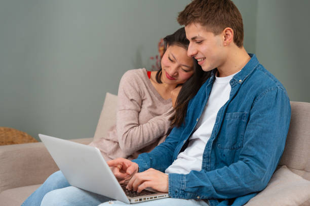 istock Happy multiethnic man and woman have fun browsing internet on laptop. Technology concept. 2010213360