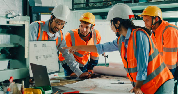 istock Team of industrial engineers meeting analyze machinery blueprints consult project on table in manufacturing factory. Working in manufacturing plant or production plant. 2010222449