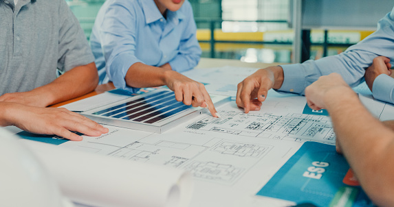 Closeup team of industrial engineers brainstorming of sustainability renewable energy working focused ESG environmental considerations in manufacturing factory. Sustainable manufacturing plant concept.