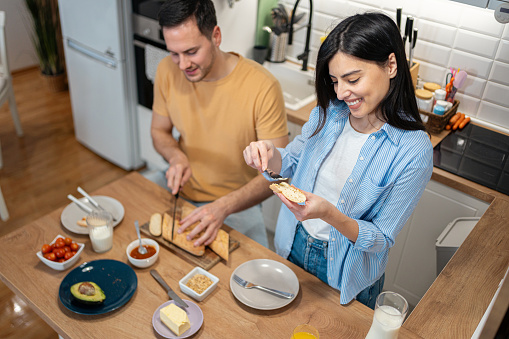 Young Caucasian couple, making an breakfast in their modern kitchen
