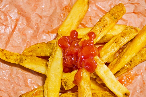 A closer look of a stack of fries with ketchup