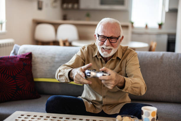istock A stylish senior man plays a video game using a joystick, representing the essence of a contemporary grandpa. 2010259437