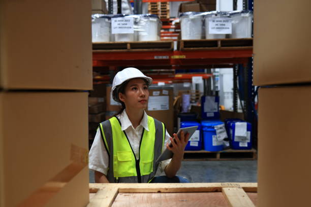 istock female logistic engineer working in warehouses use digital table to ensure the quality of cartons packaged on racks or shelves, Logistics, Import, Export, and Distribution warehouse. 2010262239